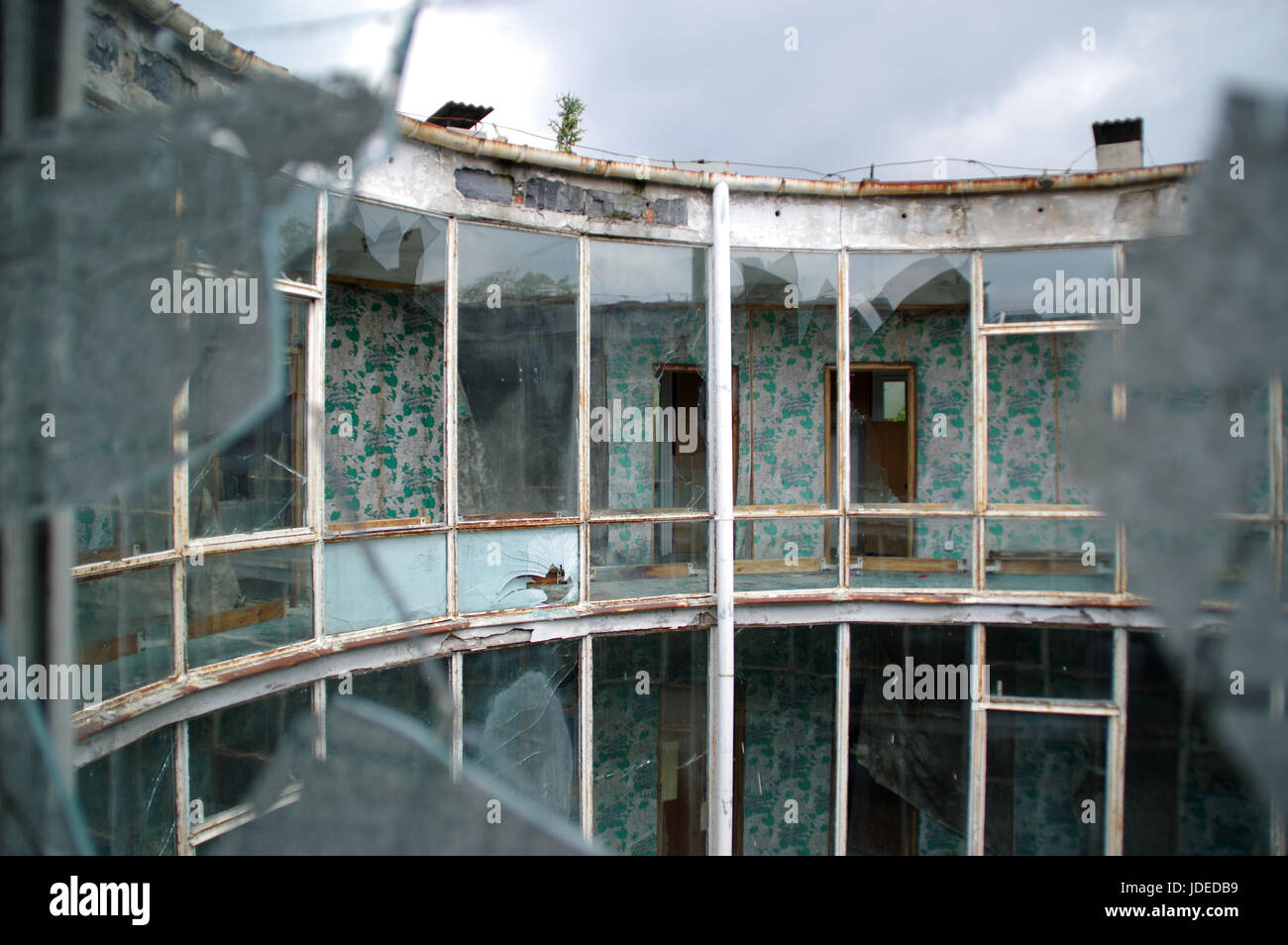 Dimenticato edificio rotondo con vetro frantumato. Rotto nel riquadro di windows. Foto Stock