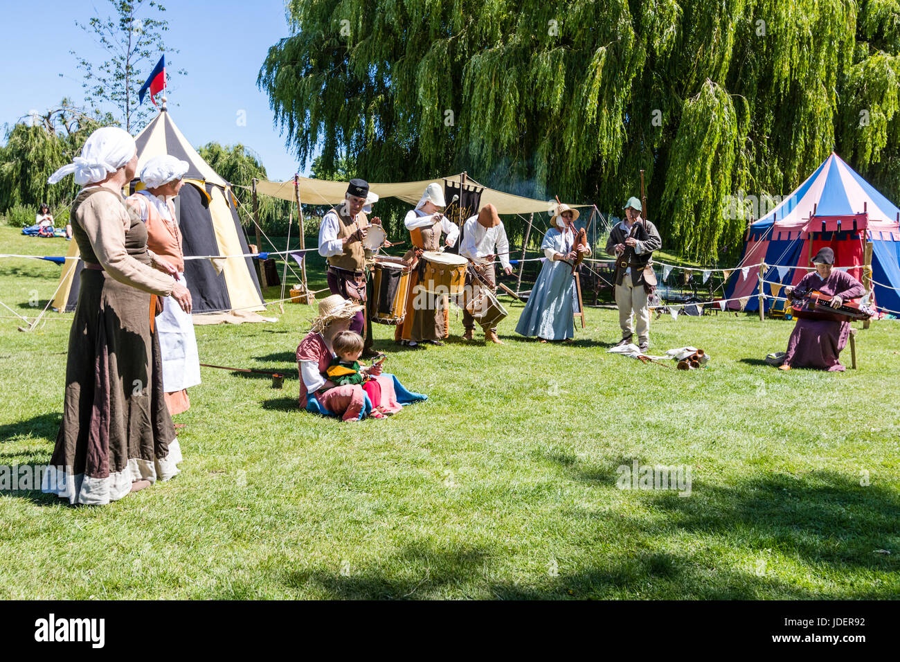 Medievale Musicke ruvida storia viva menestrello gruppo di eseguire sul verde, Sandwich città. Fila di musicisti vestiti in costumi medievali. Foto Stock