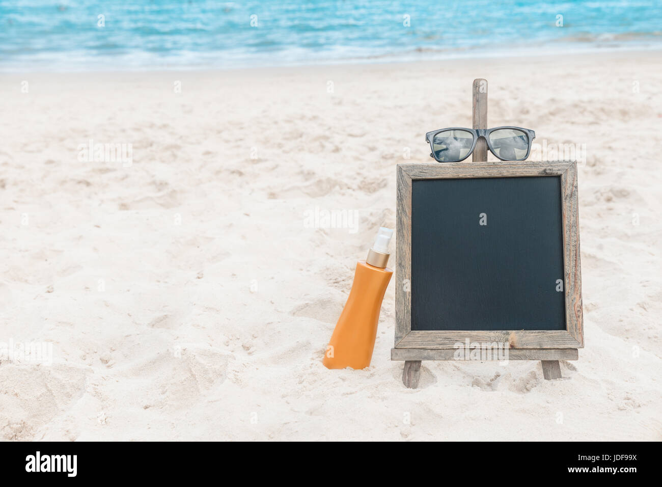 Chalk board con crema di protezione solare nella sabbia sulla spiaggia tropic sfondo esotico Foto Stock