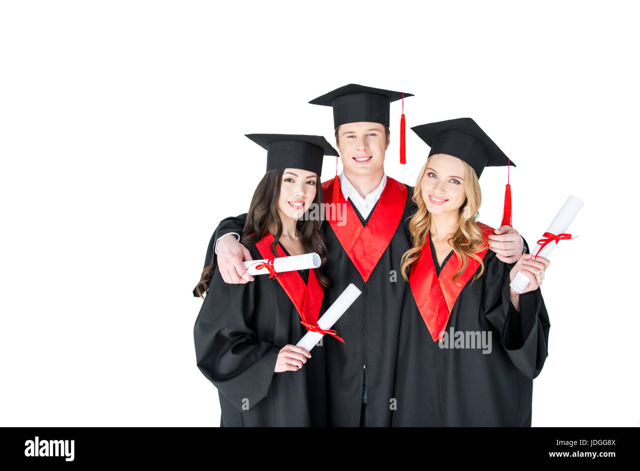 Felice gli studenti nel mondo accademico caps abbracciando permanente con diplomi e guardando la fotocamera Foto Stock