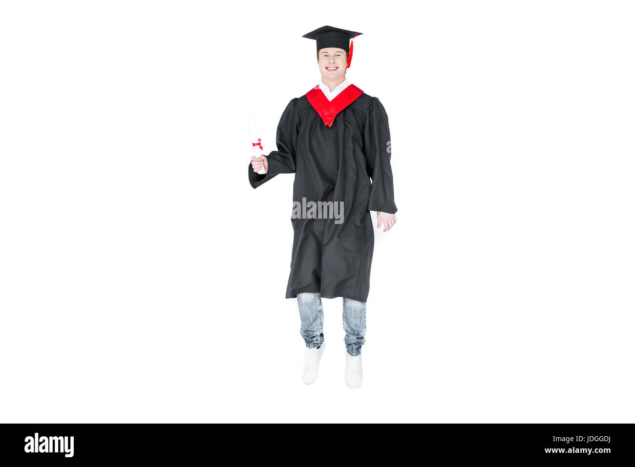 Giovane studente nel tappo di graduazione con diploma jumping isolato su bianco Foto Stock