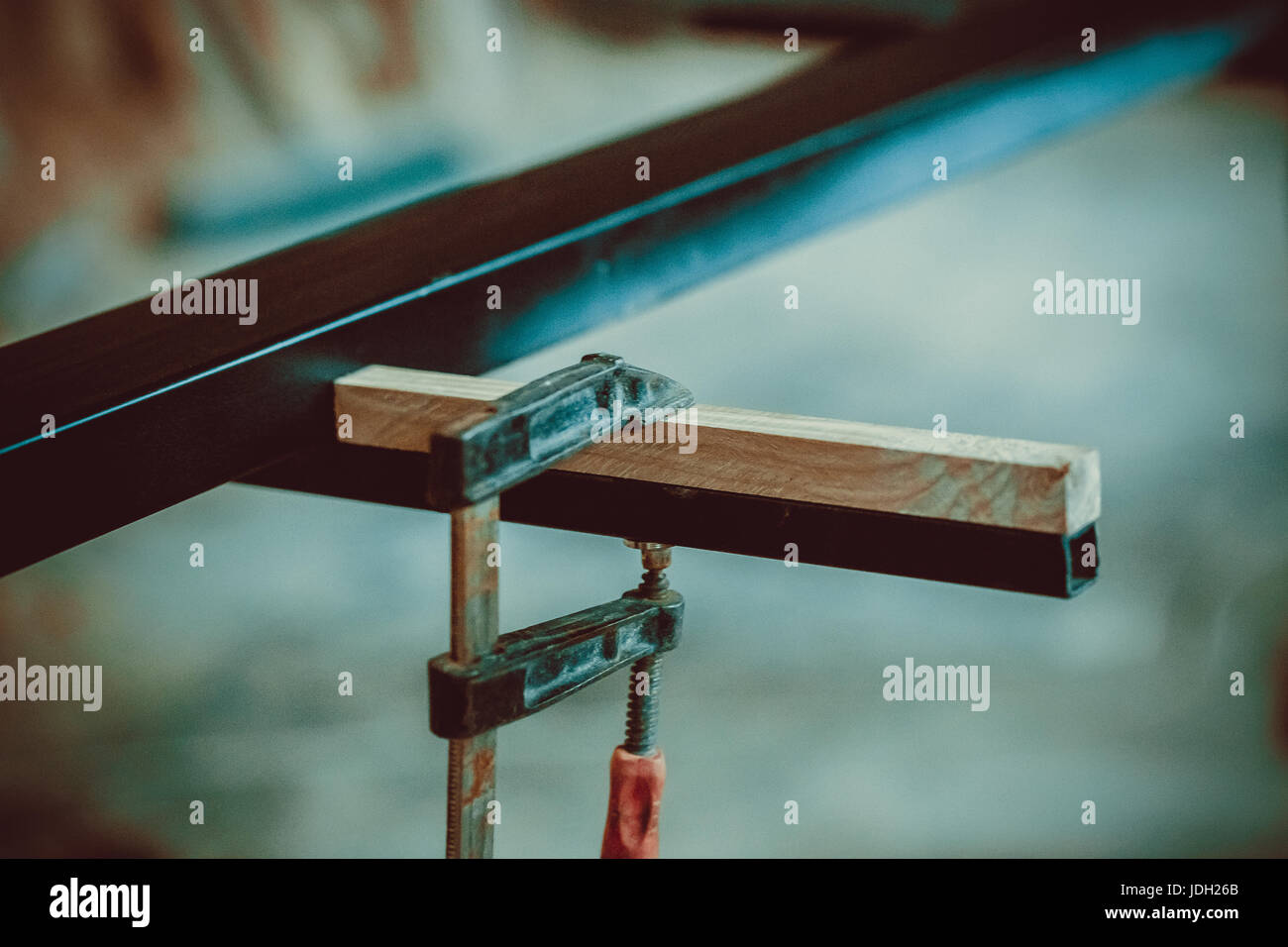 Artigiano utilizzando le fascette fissare due pezzi di legno e ferro da stiro. Il processo di fare escursioni, mobili. soft focus. shallow dof. Foto Stock