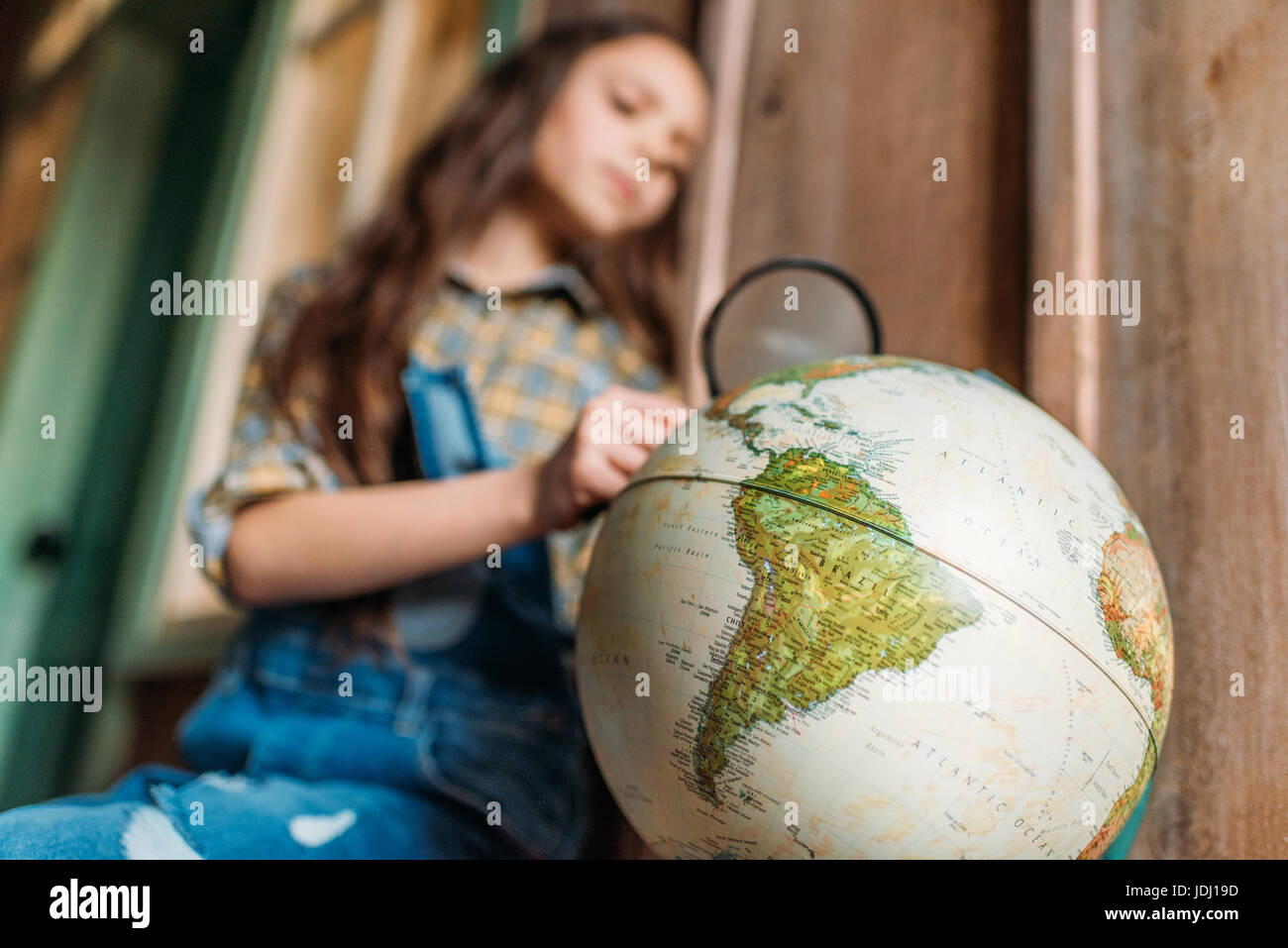 Bambina con lente di ingrandimento e globo. istruzione concetto per bambini Foto Stock