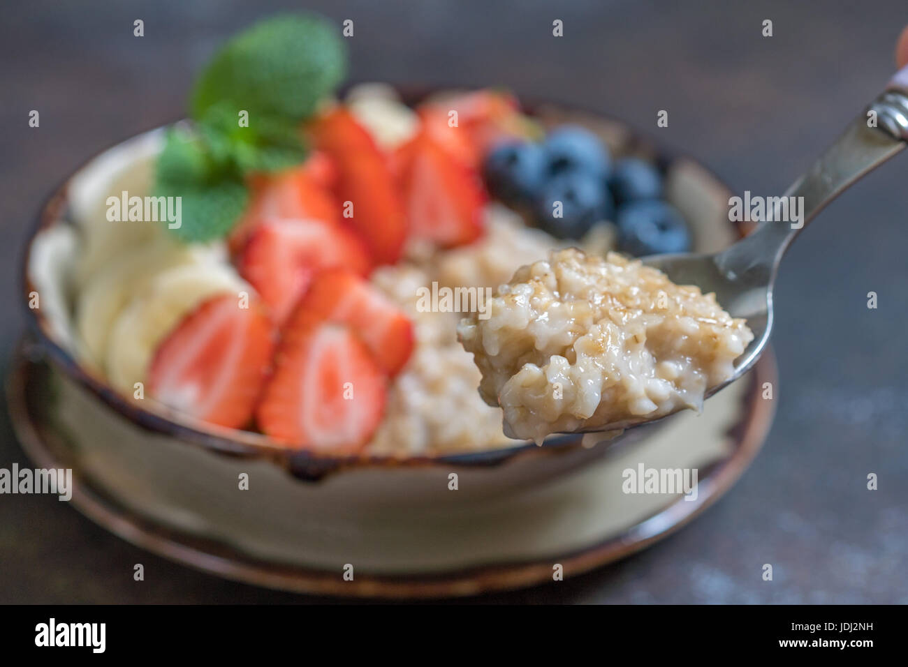 Ciotola di deliziose acciaio tagliati di avena con frutta fresca, miele Foto Stock