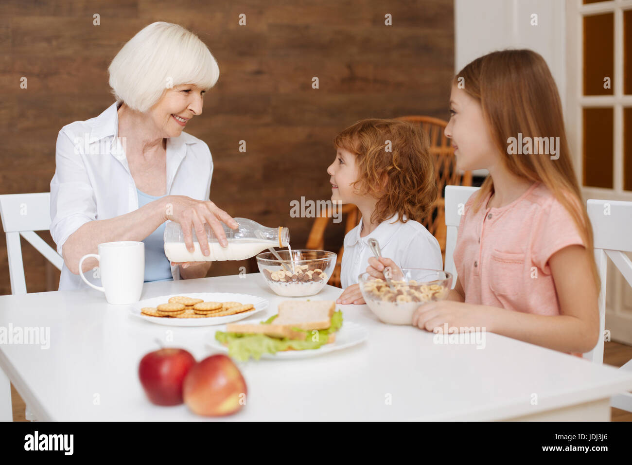 Un sincero ragazzi e i loro nonna godendo di una conversazione di mattina Foto Stock