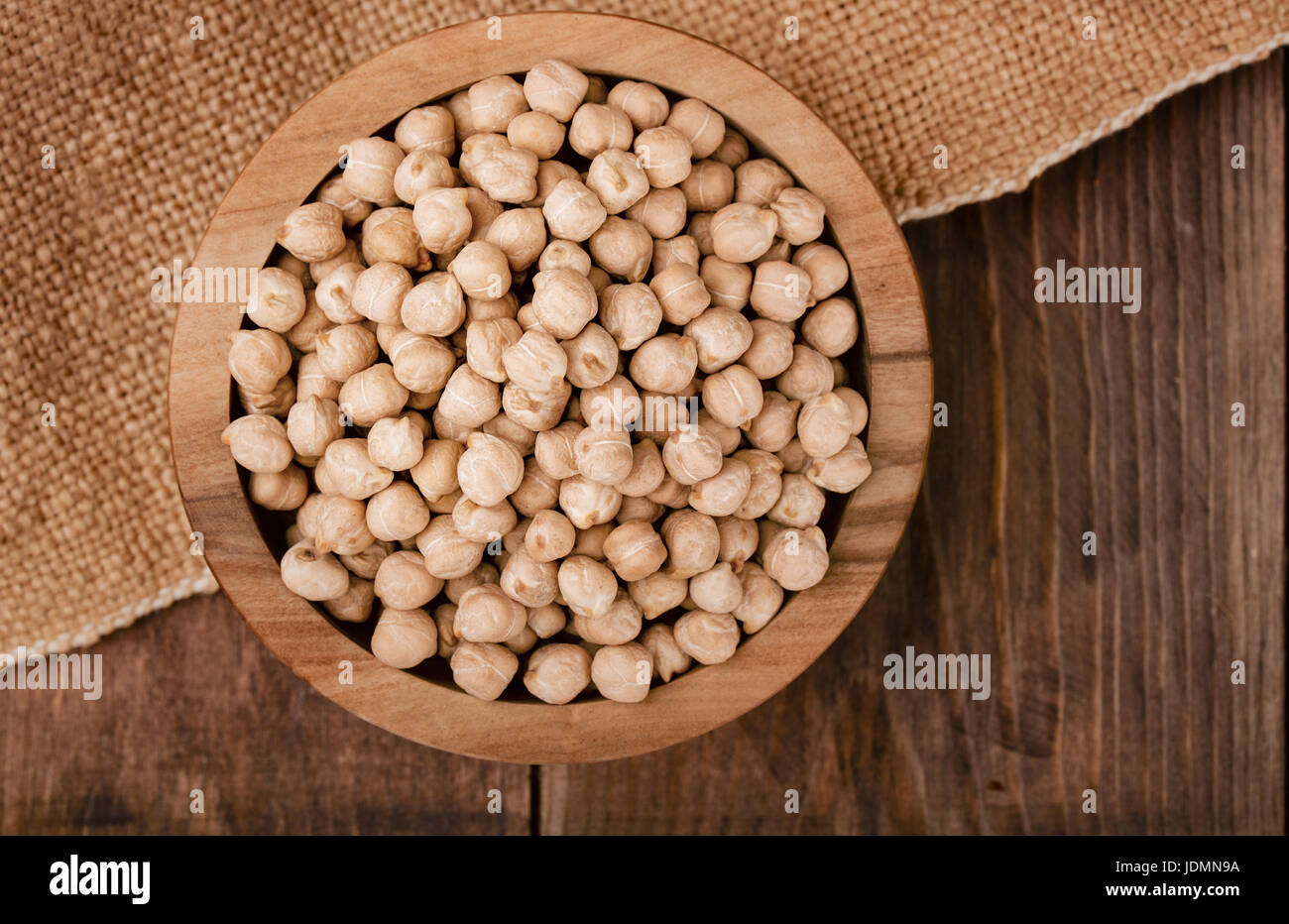 Vista superiore della secca chickpeasl vaso su sfondo di legno. Foto Stock