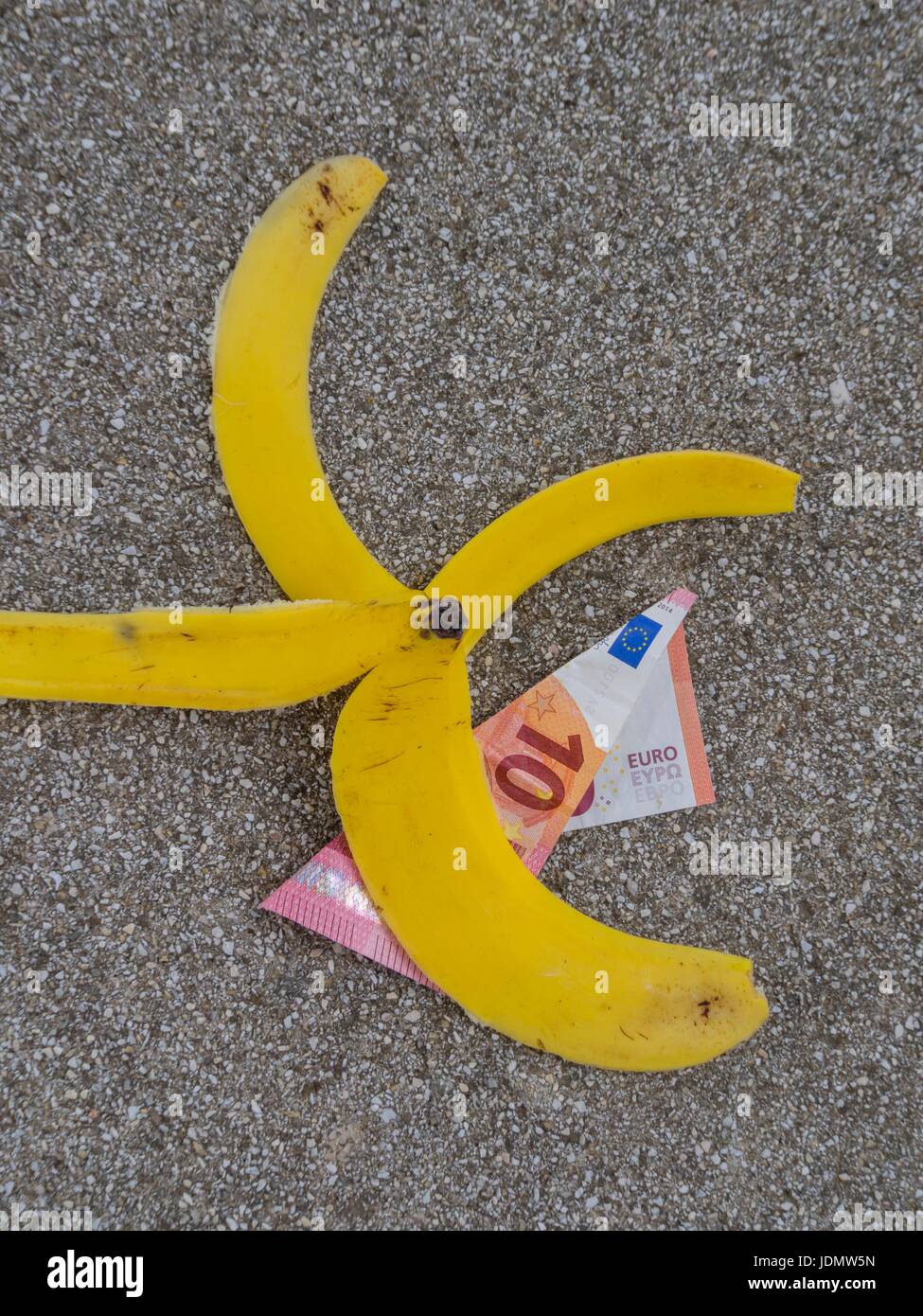 Slip scivolato denaro banana sul terreno su strada Foto Stock