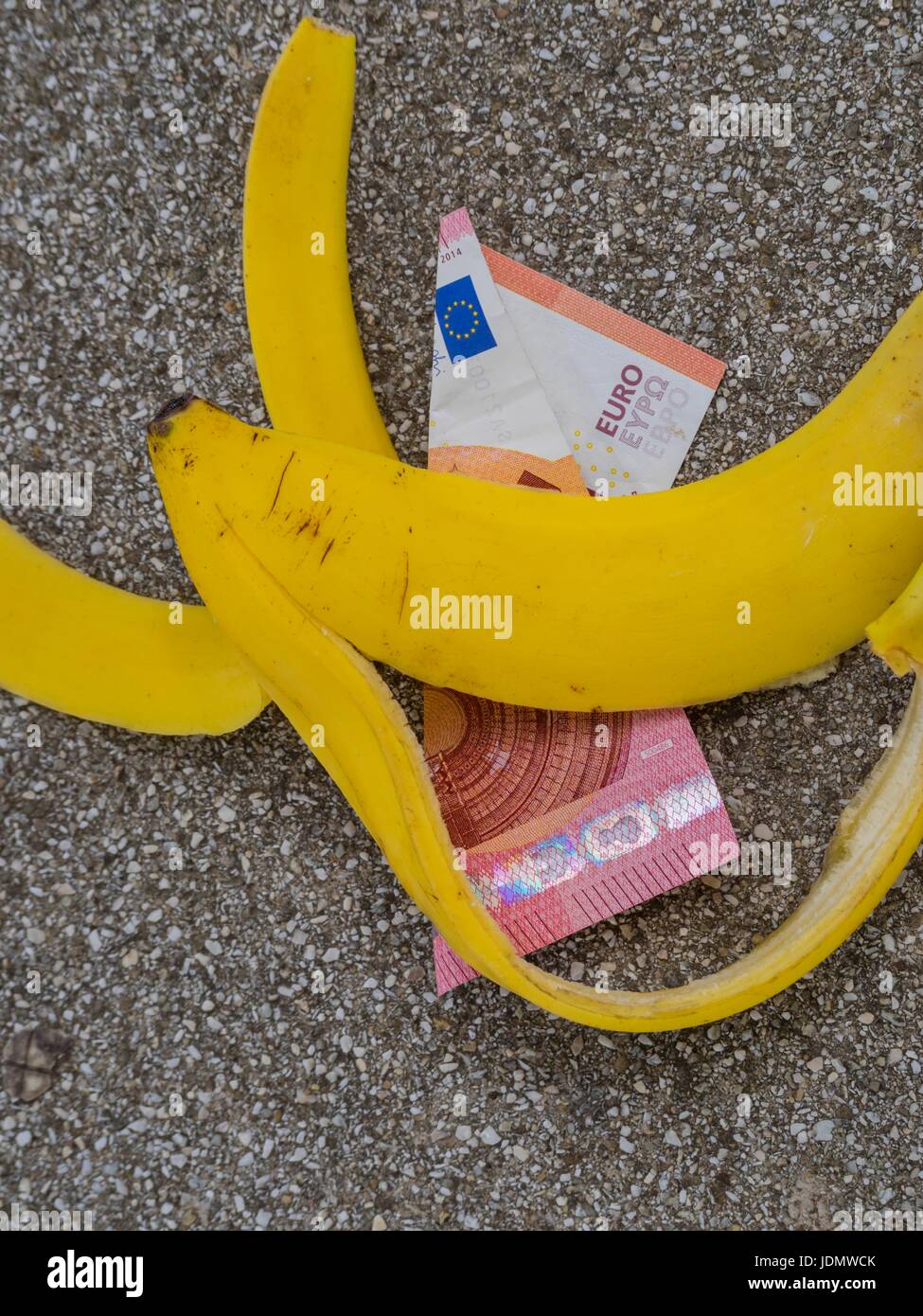 Slip scivolato denaro banana sul terreno su strada Foto Stock