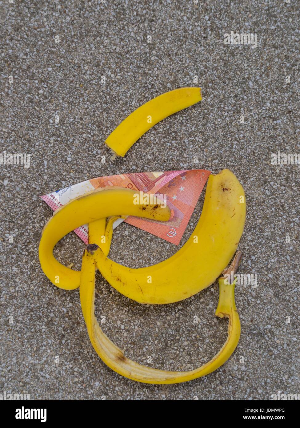 Slip scivolato denaro banana sul terreno su strada Euro UE Foto Stock