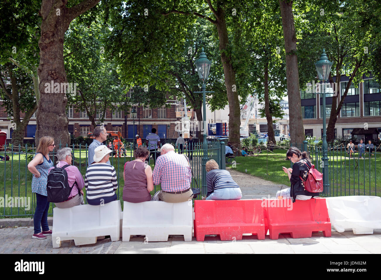 I turisti seduti, Charterhouse Square, boarder del London borough di Islington & City di Londra Inghilterra Gran Bretagna REGNO UNITO Foto Stock