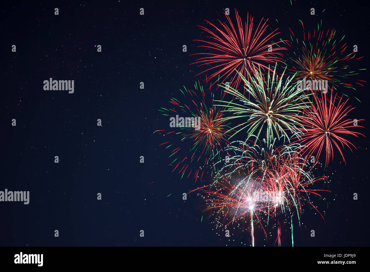 Incredibile rosso verde giallo celebrazione fuochi d'artificio che si trova a destra oltre il cielo notturno, copia dello spazio. Giorno di indipendenza, 4 luglio, le vacanze di Capodanno Saluto Foto Stock