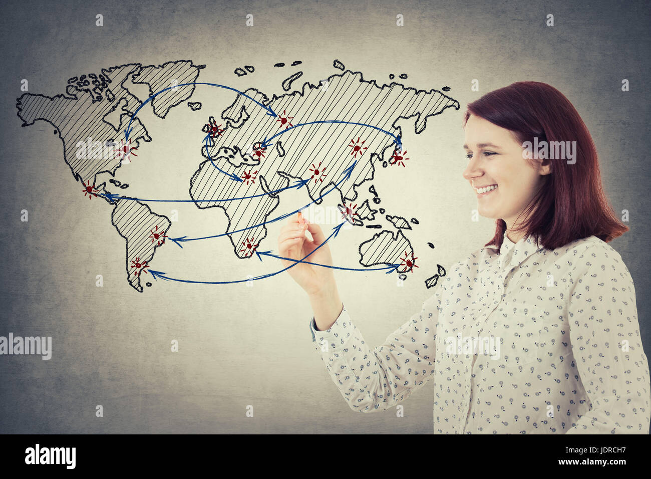 Giovane imprenditrice sorridente tenendo una matita nel suo disegno a mano un fantasioso schizzo della mappa del mondo e il collegamento tra i vari paesi. Global n Foto Stock