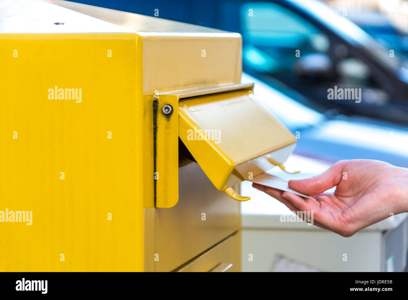 Gettando una lettera in tedesco mailbox giallo Foto Stock