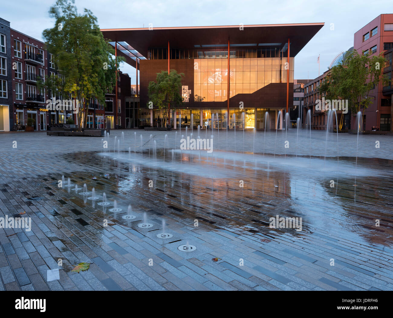 Moderno museo di patatine fritte al tramonto nel centro della vecchia capitale di provincia leeuwarden della Frisia nei Paesi Bassi con riflessi nell'acqua della fontana Foto Stock