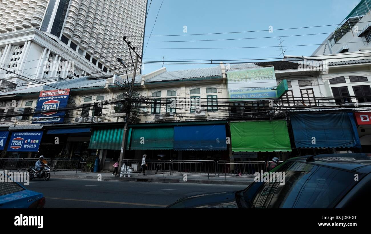 Gli edifici di cavi elettrici vibranti diurno urbano persone Charoen Krung Road Sathon Bangkok in Thailandia Foto Stock