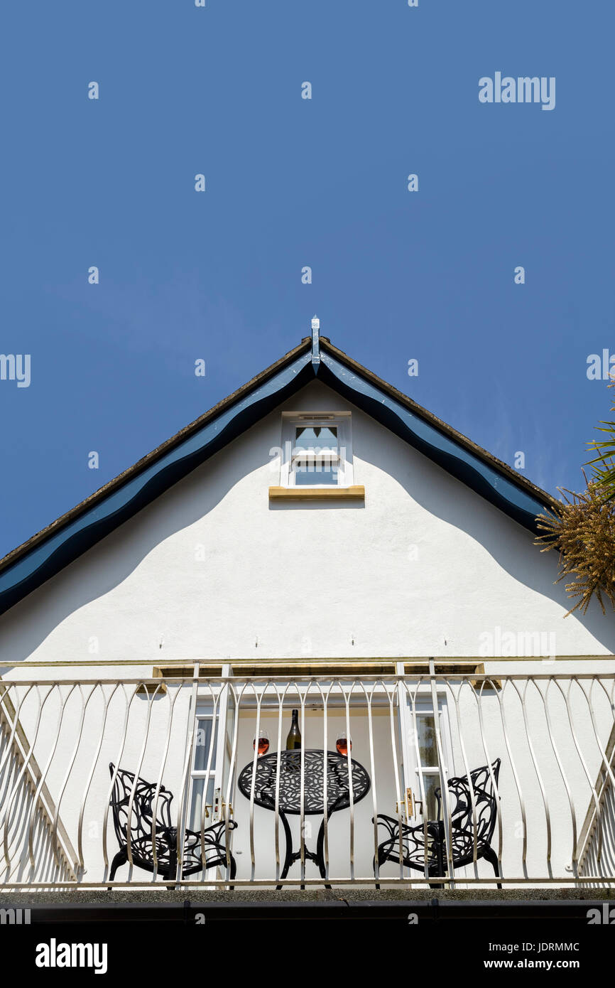 Balcone che conducono fuori della camera da letto un bianco casa murata con tavolo,bicchieri,vino,blue sky a metà estate. Foto Stock