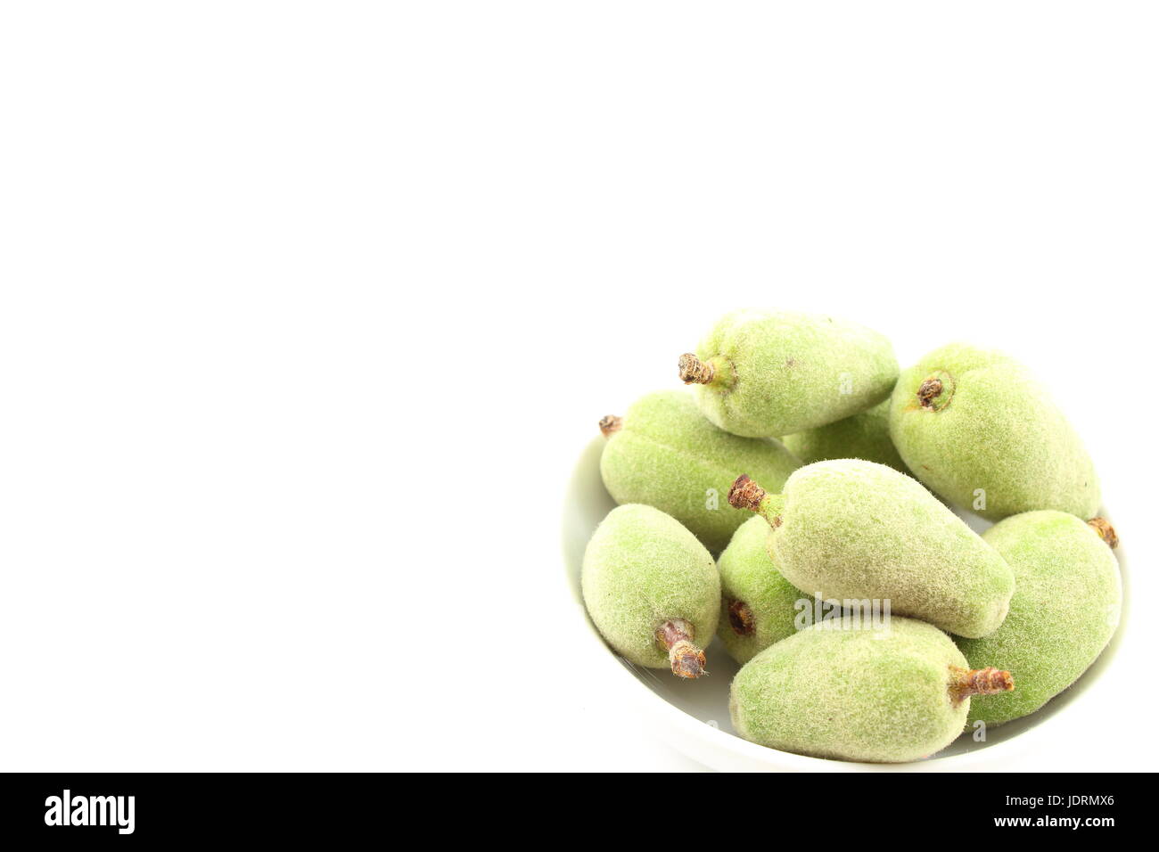 Composizione del fresco verde mandorla frutti in una piccola ciotola bianco Foto Stock