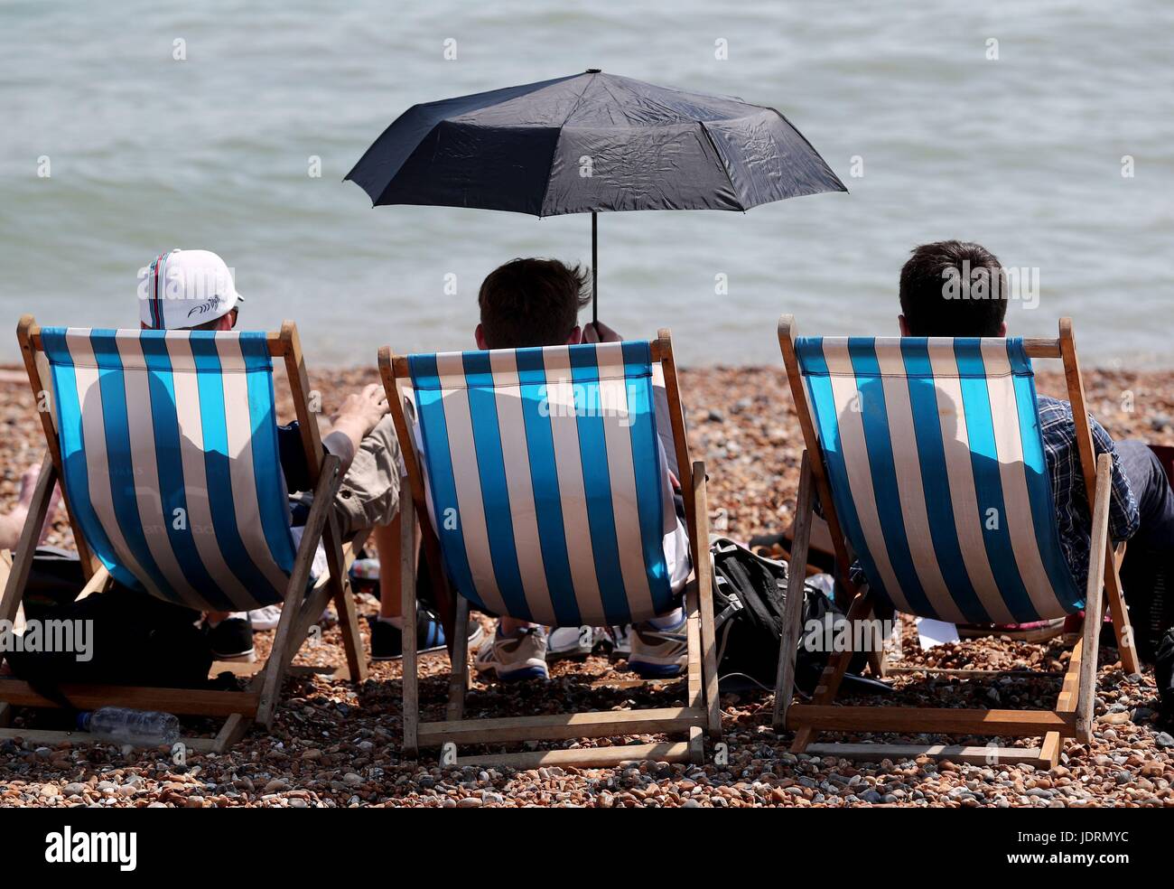 Persone godere il caldo sulla spiaggia di Brighton, East Sussex. La temperatura ha colpito 33.9C (93F) all'aeroporto di Heathrow a Londra ad ovest, rendendolo il più caldo giorno di Giugno a partire dal 1976, il Met Office ha detto. Foto Stock