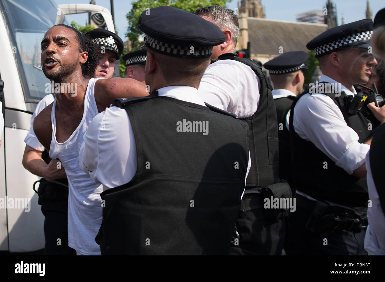 La polizia di trattenere un uomo a una protesta al di fuori del Palazzo di Westminster a Londra in seguito lo stato apertura del Parlamento. Foto Stock