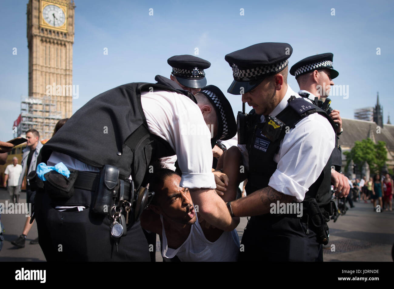 La polizia di trattenere un uomo a una protesta al di fuori del Palazzo di Westminster a Londra in seguito lo stato apertura del Parlamento. Foto Stock