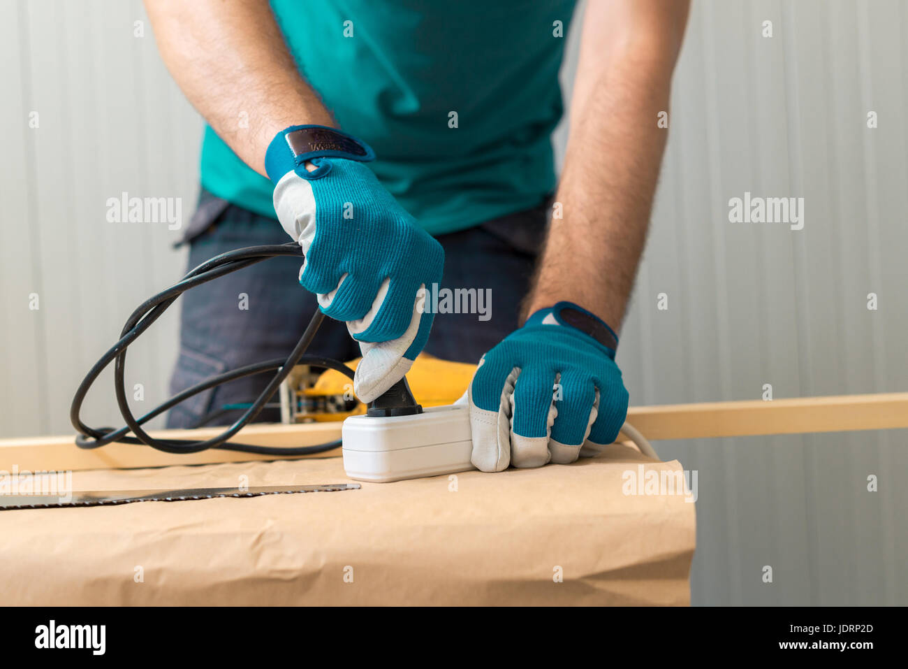 Falegname tuttofare tamponamento a portata di mano elettrico visto su legno tabella di officina Foto Stock