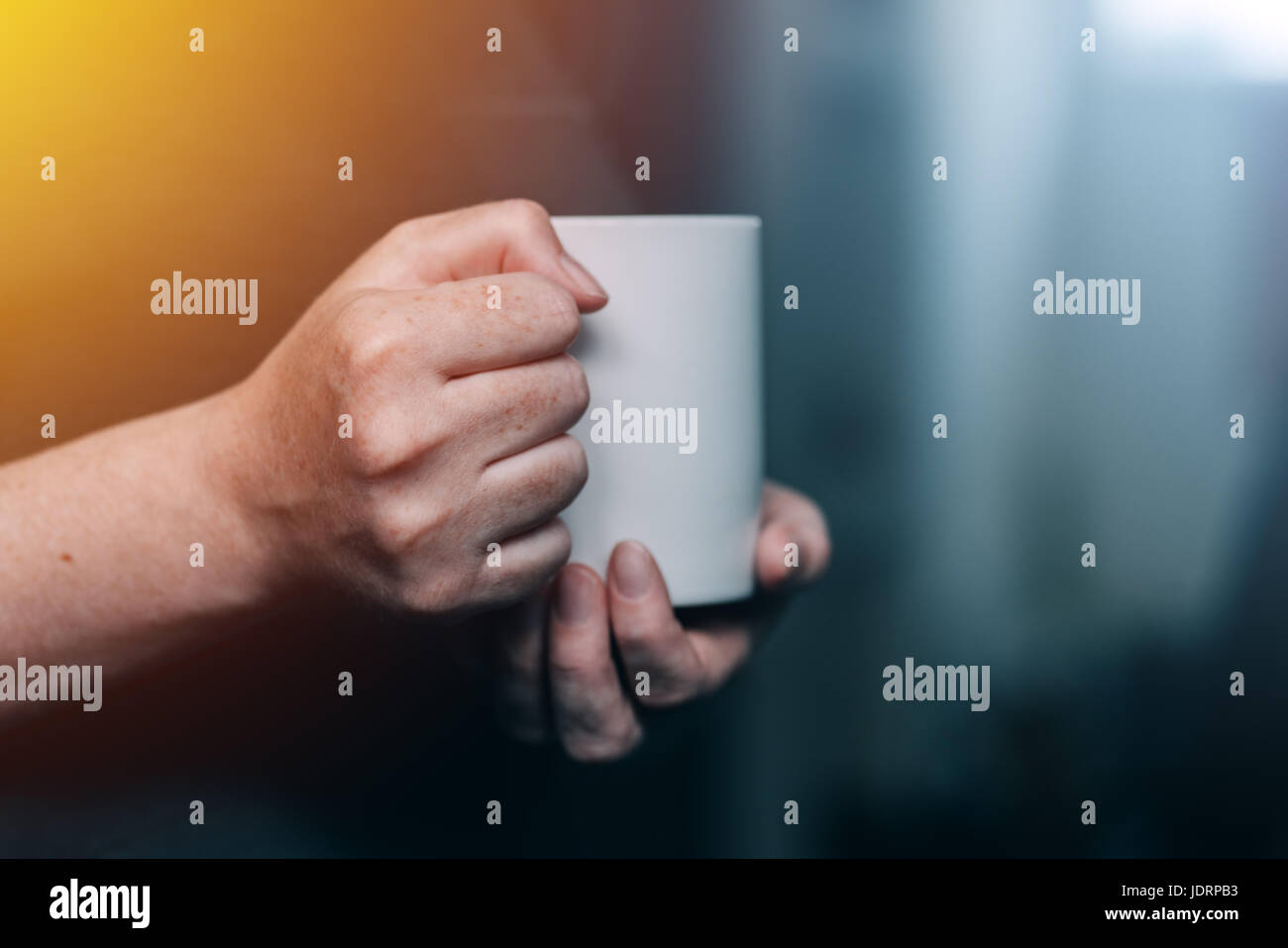 Donna di bere il caffè al mattino, close up di mani femminili con tazza di caffè Foto Stock