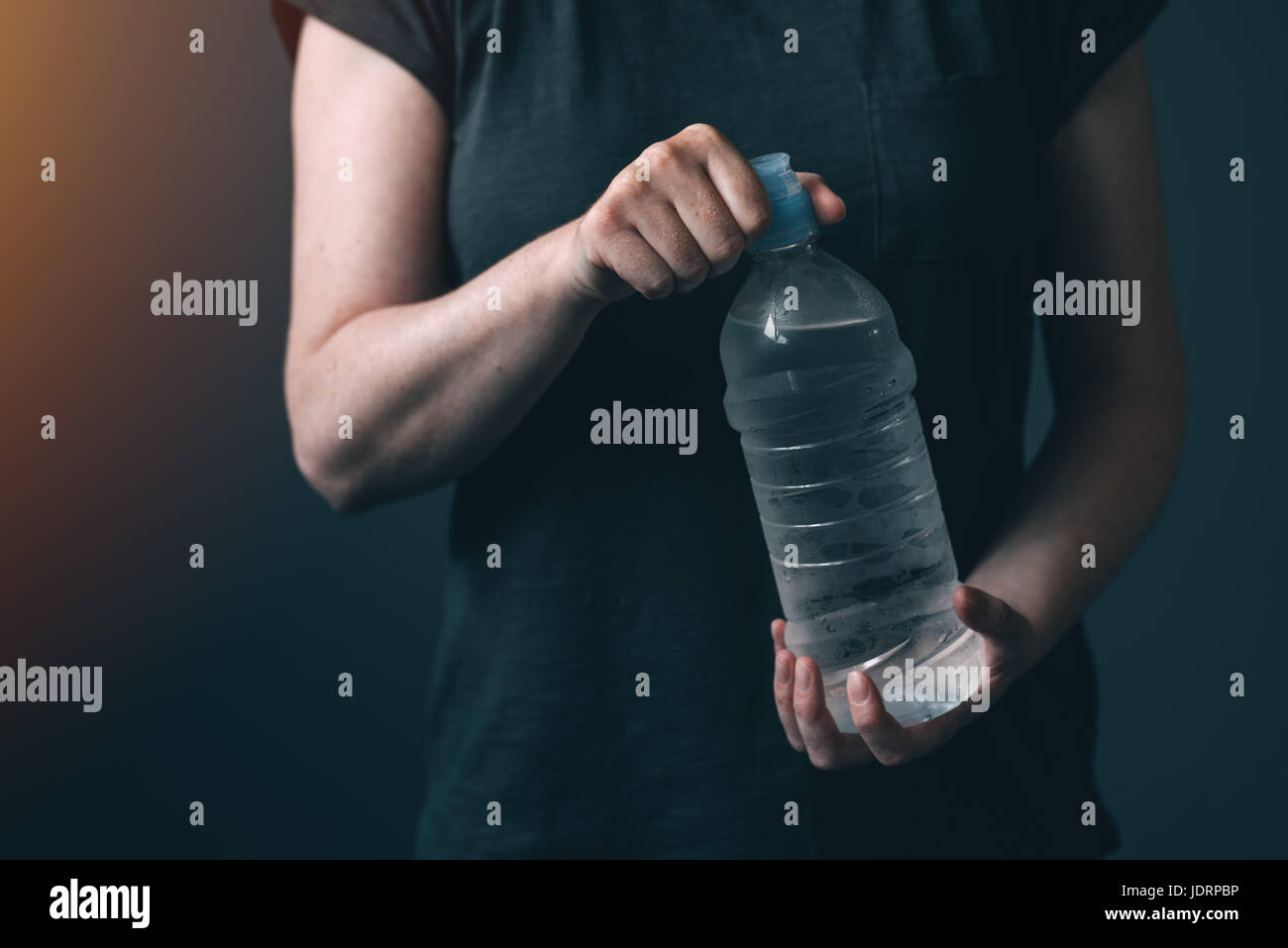 Donna con una bottiglia di acqua fresca potabile per il ristoro e reidratazione Foto Stock