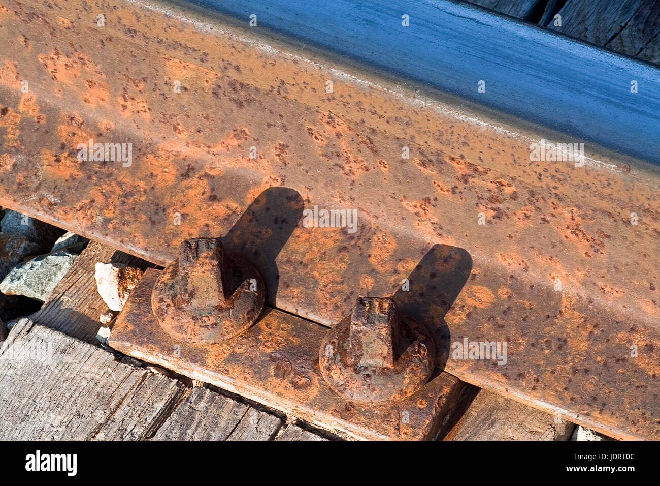 Dettaglio del percorso del treno con viti logore ed ossidato mediante il passaggio del tempo Foto Stock