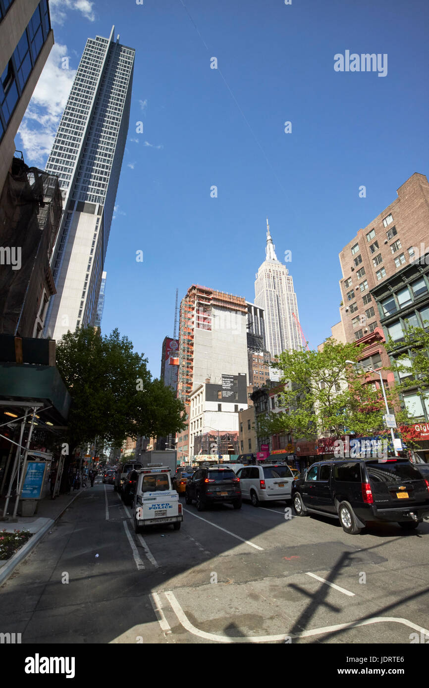 Guardando in alto lungo la 6th avenue tra Chelsea (sinistra) e nomad (destra) con vista dell'Empire State Building di New York City STATI UNITI D'AMERICA Foto Stock