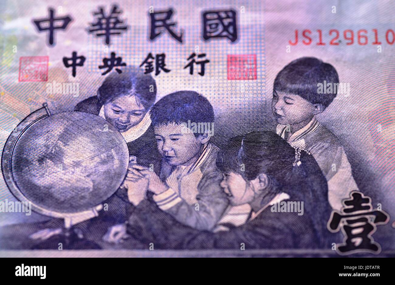 Vista ingrandita su una porzione di un 1000 Taiwan dollaro che mostra i caratteri cinesi e quattro ragazzi che sono in cerca di un globo Foto Stock