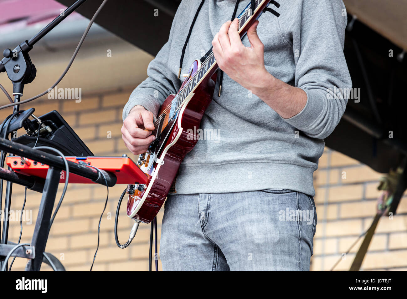 Le mani del giovane musicista suonare la chitarra elettro durante la performance della città Foto Stock