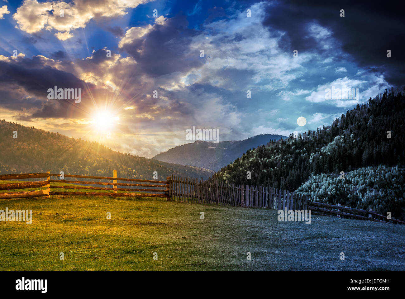 Il giorno e la notte e cambiare idea. staccionata in legno attraverso il prato erboso nelle montagne dei Carpazi bellissimo paesaggio di campagna con cielo nuvoloso wit Foto Stock