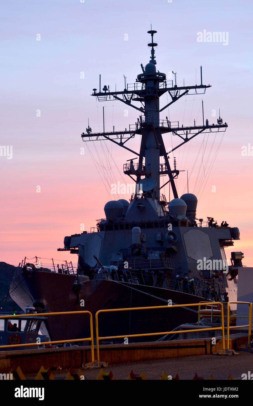 U.S Navy Arleigh Burke-class missile destroyer USS Fitzgerald tira nel dock dopo il rientro al porto a seguito di una collisione in mare con una nave mercantile Giugno 17, 2017 a Yokosuka, Giappone. La collisione ha provocato la morte di sette marinai e ingenti danni alla nave da guerra. Foto Stock