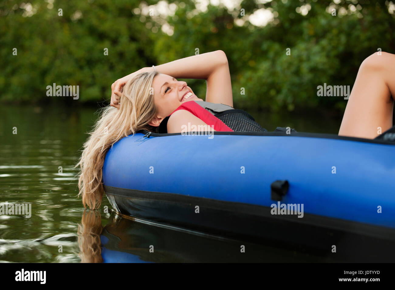 Donna rilassante in kayak in creek Foto Stock