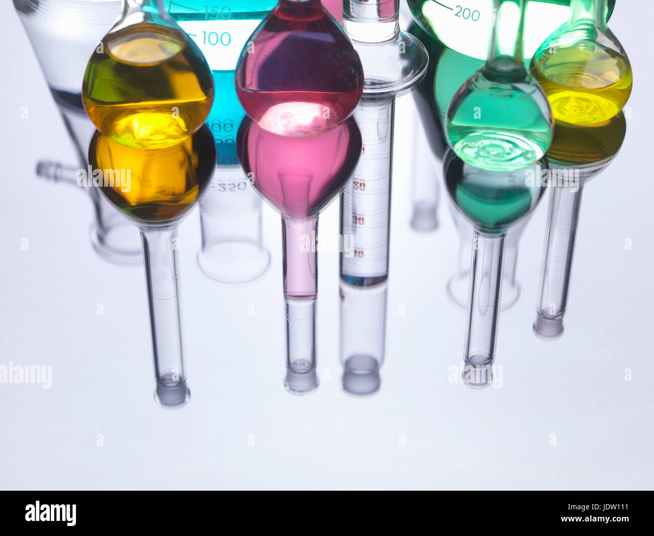 Bicchieri con liquidi sul piano riflettente Foto Stock