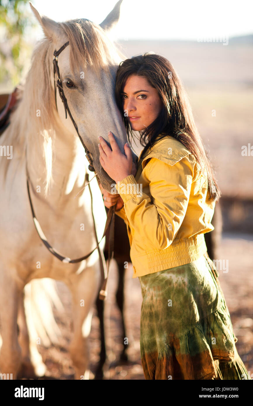 Giovane donna toccando cavallo del volto Foto Stock