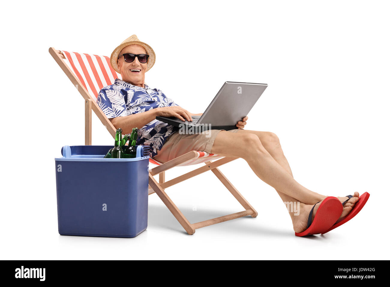 Anziani turistico con un laptop seduto in una sedia a sdraio accanto a una scatola di raffreddamento e guardando la telecamera isolata su sfondo bianco Foto Stock