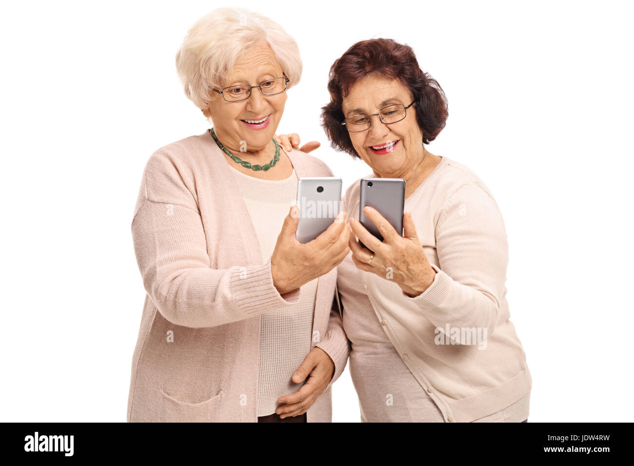 Due donne anziane guardando telefoni isolati su sfondo bianco Foto Stock