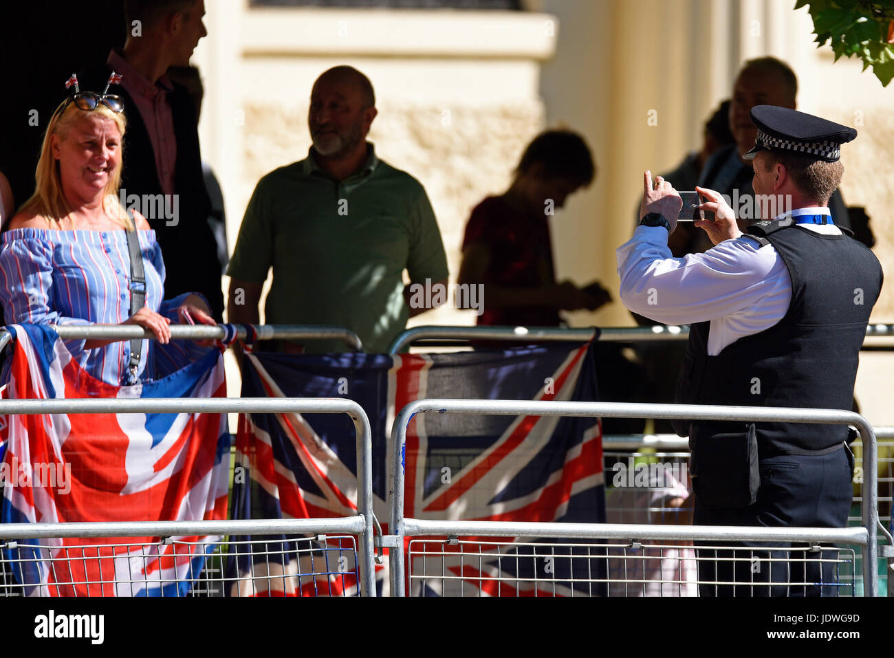 Poliziotto che scatta una foto di un membro del pubblico al Trooping the Colour 2017 in The Mall, Londra, Regno Unito Foto Stock