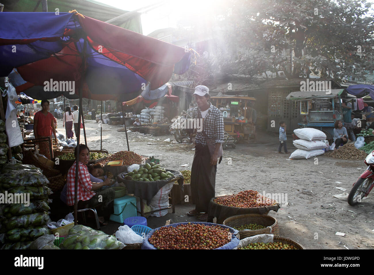 Mercato Zegyo/Mandalay - Myanmar 22 Gennaio 2016: un vegetale vedor è impegnato in una conversazione testuale con un cliente mentre il suo collega havin è un pisolino nel tardo afternoo Foto Stock