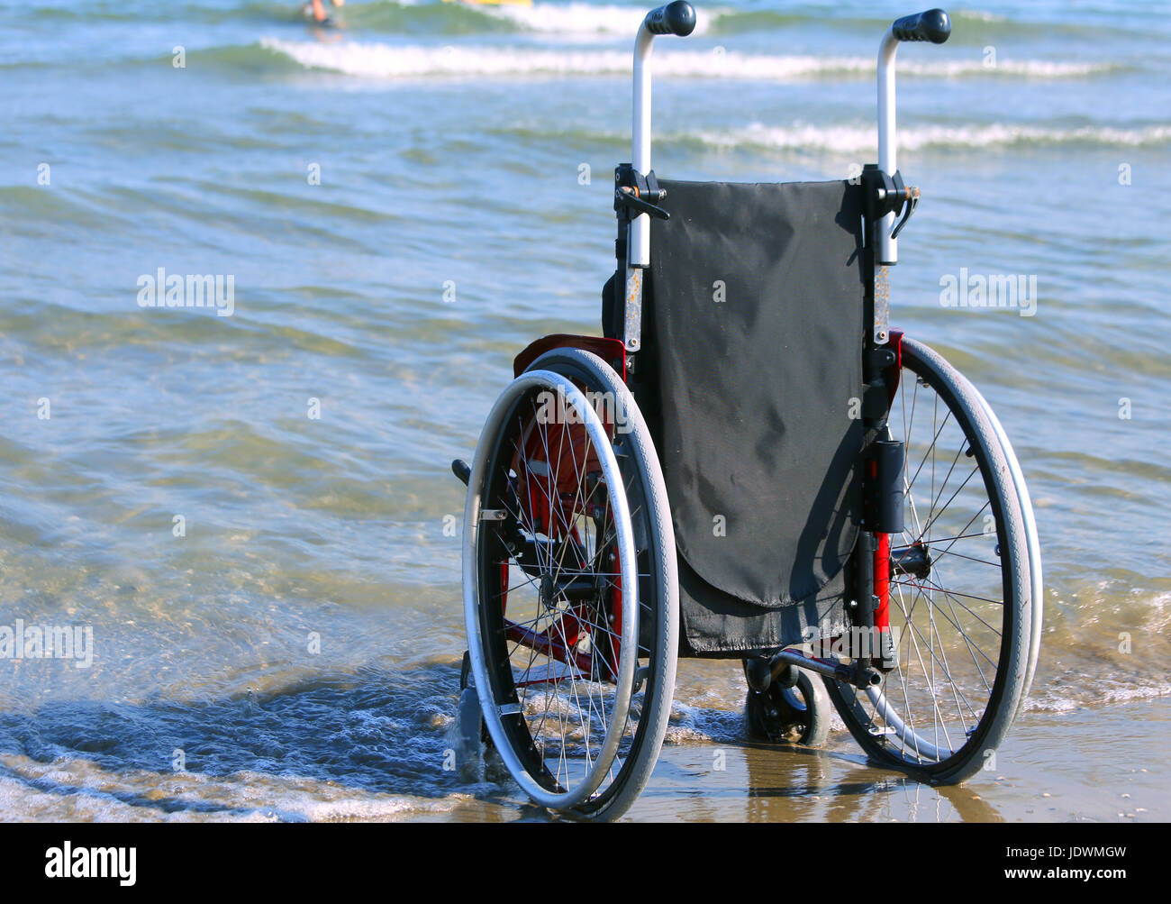 Sedia a rotelle sulla riva con l'oceano in un caldo giorno d'estate e di sole Foto Stock