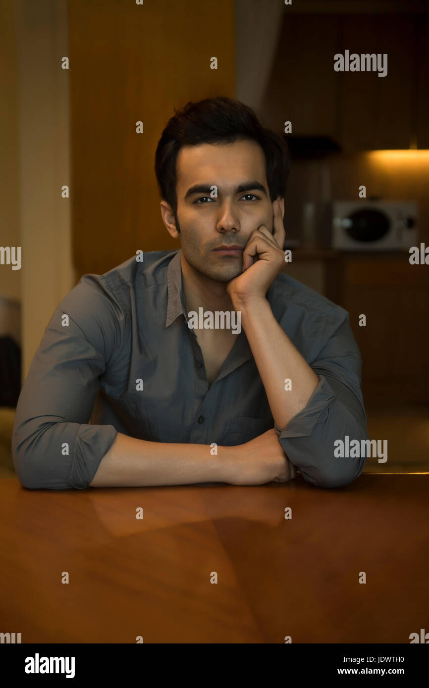Ritratto di giovane uomo di pensare con la mano sul mento Foto Stock