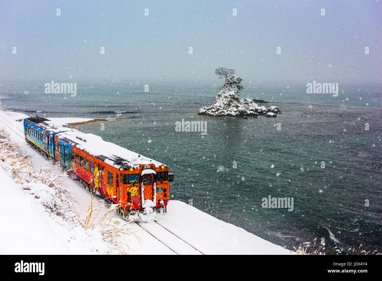 Costa Amaharashi Quasi-National Park, Giappone - 23 gennaio 2017: una linea Himi treno passa la costa Amaharashi durante l'inverno. Foto Stock