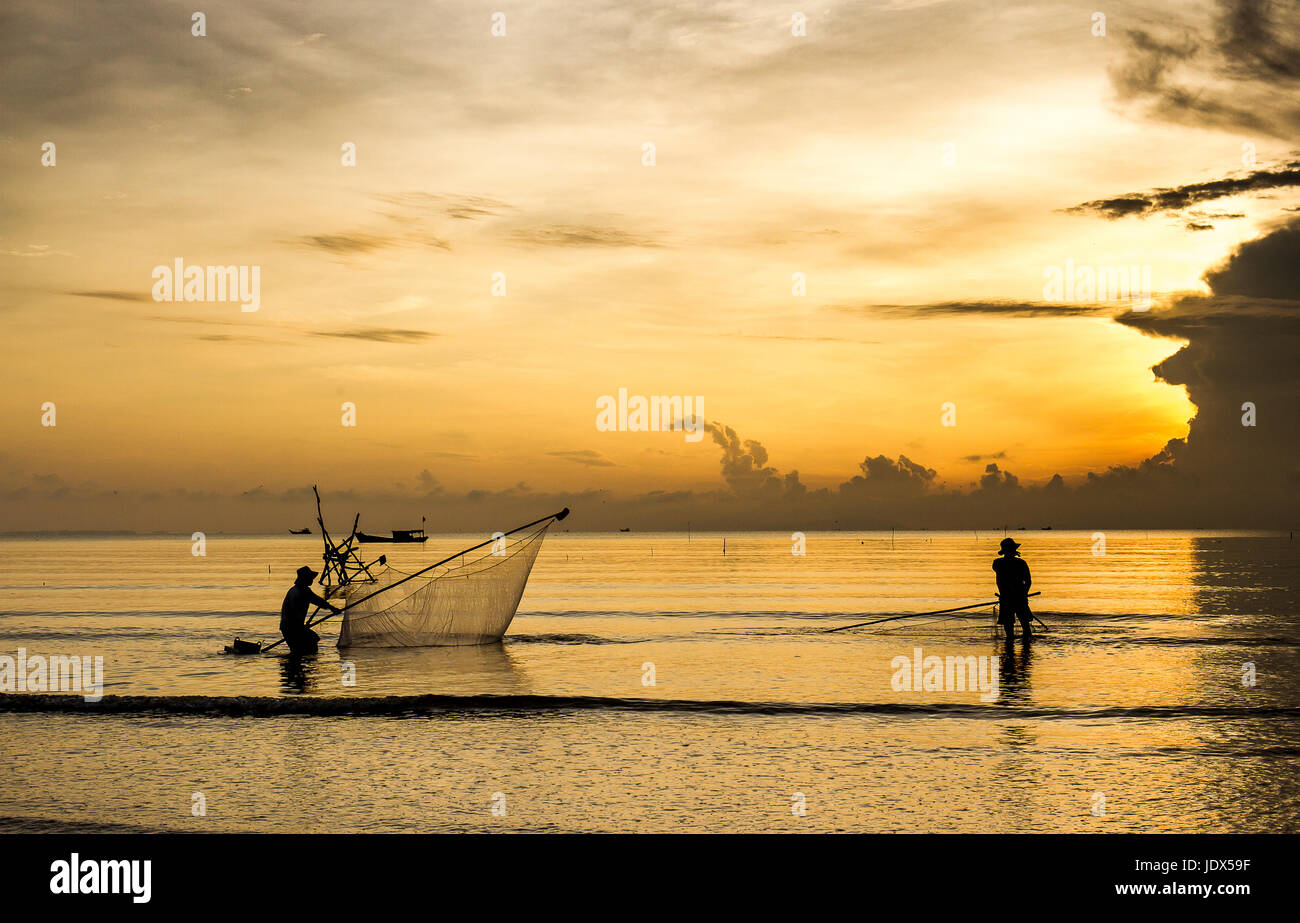 Mare clam pescatori di scavo golden sunrise Tan Thanh beach Go Cong Tien Giang Viet Nam Foto Stock