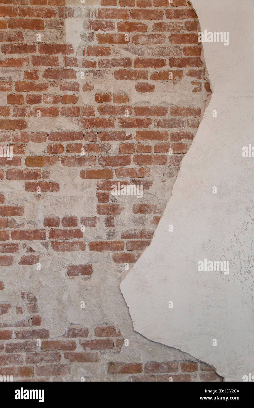 Abstract di mattoni rossi e sfondo intonaco danneggiato testura sabbiosa. Foto Stock
