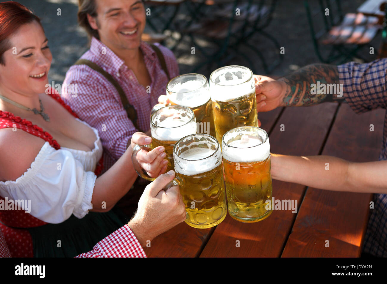 Persone in costumi tradizionali di bere birra in una birra bavarese e giardino Foto Stock