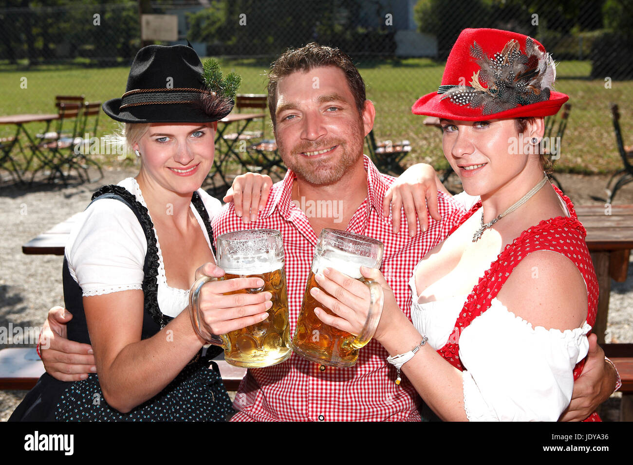 Tre bavaresi seduti in un giardino della birra in Baviera Foto Stock