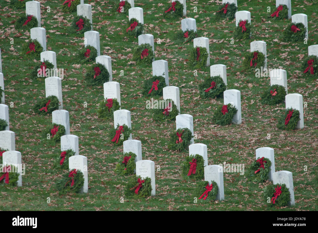 Una linea di lapidi con natale WREATS, parte di corone in tutta l'AMERICA campagna, il Cimitero Nazionale di Arlington. Foto Stock