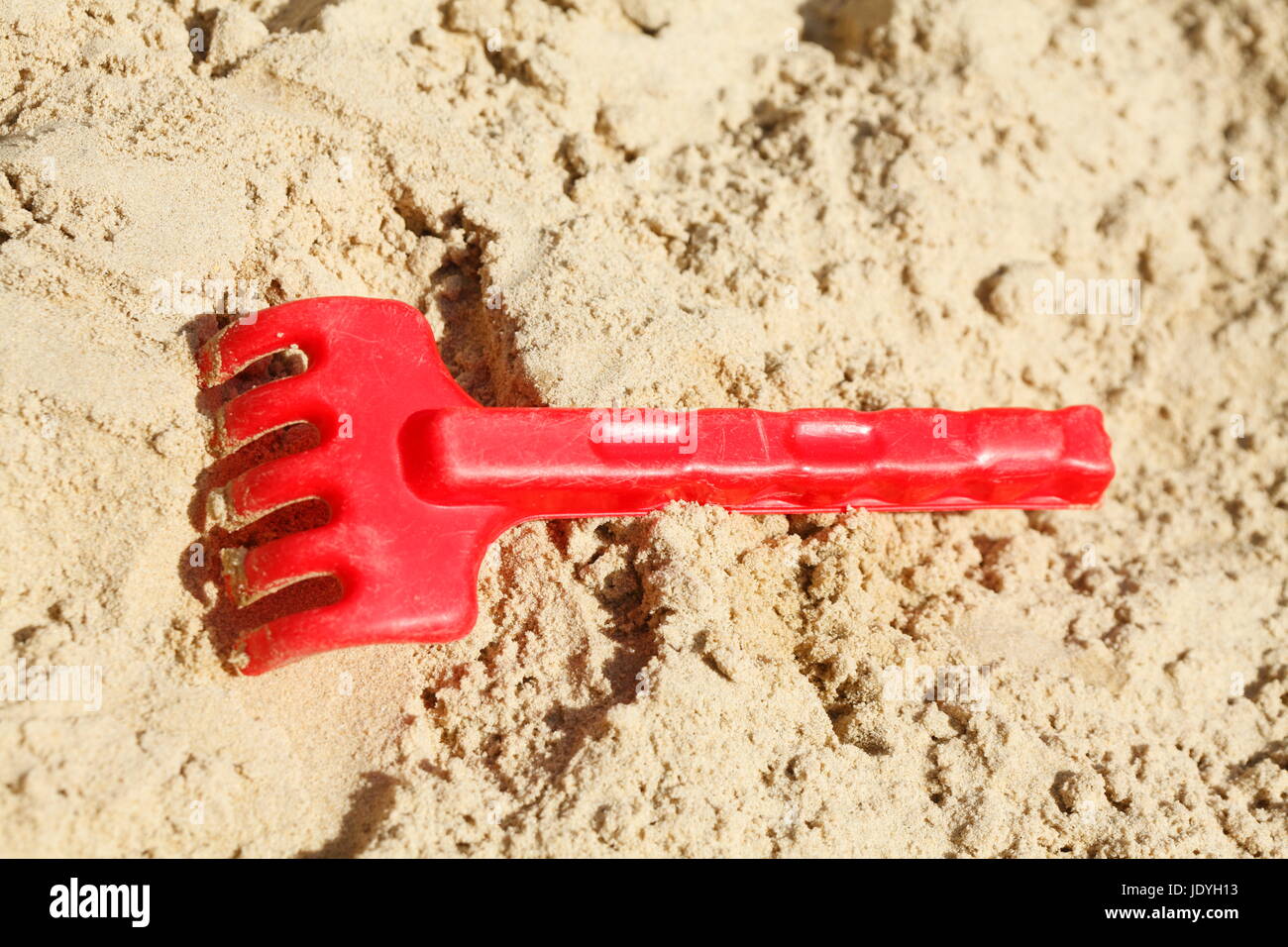 Giocattoli di plastica in una buca di sabbia su un parco giochi per i bambini Foto Stock