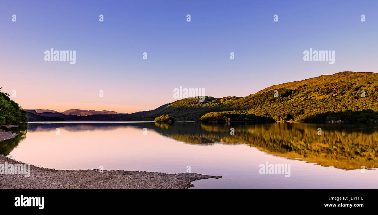Calma e splendida serata guardando a nord fino coniston water dalla sponda occidentale vicino al tramonto con riflessi e colori Foto Stock